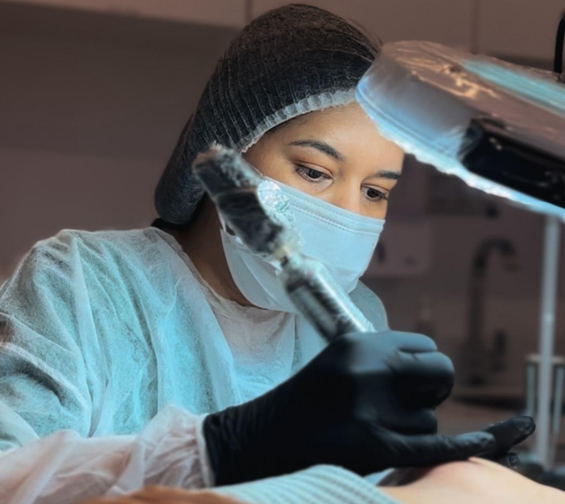 Profissional realizando o procedimento de micropigmentação da aréola em clinica.