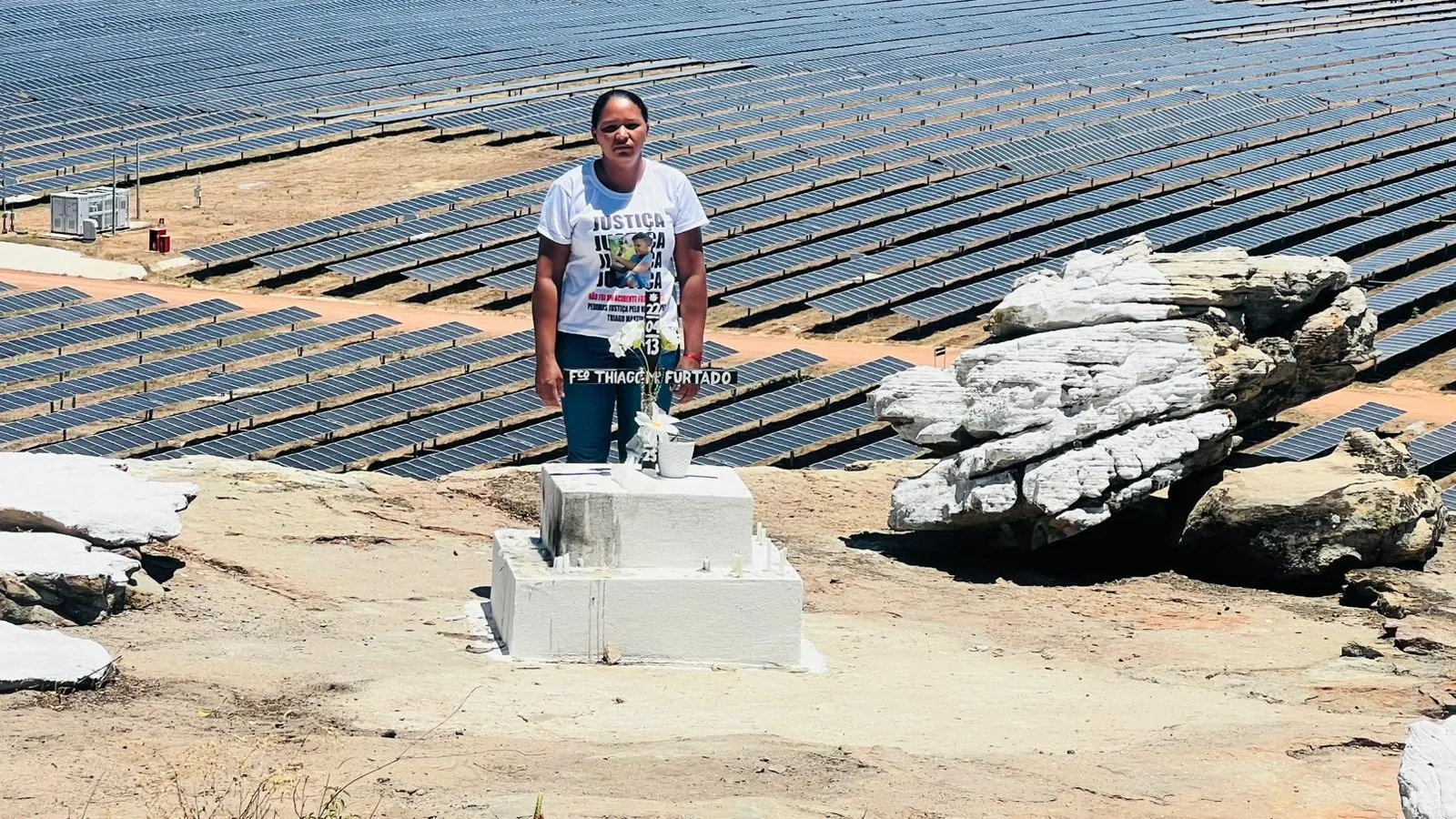 Uma mulher, com uma camiseta branca estampada com a palavra 