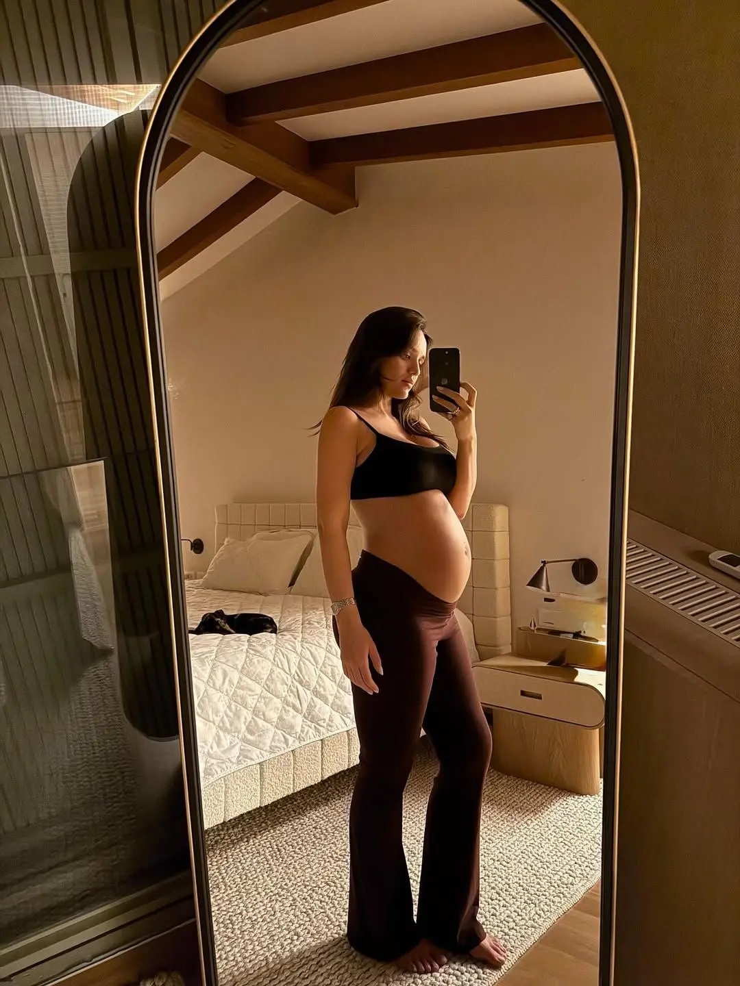 selfie da apresentadora Rafa Kalimann, que está grávida. ela beste top e calça escuras e está diante do espelho com a barriga de fora.