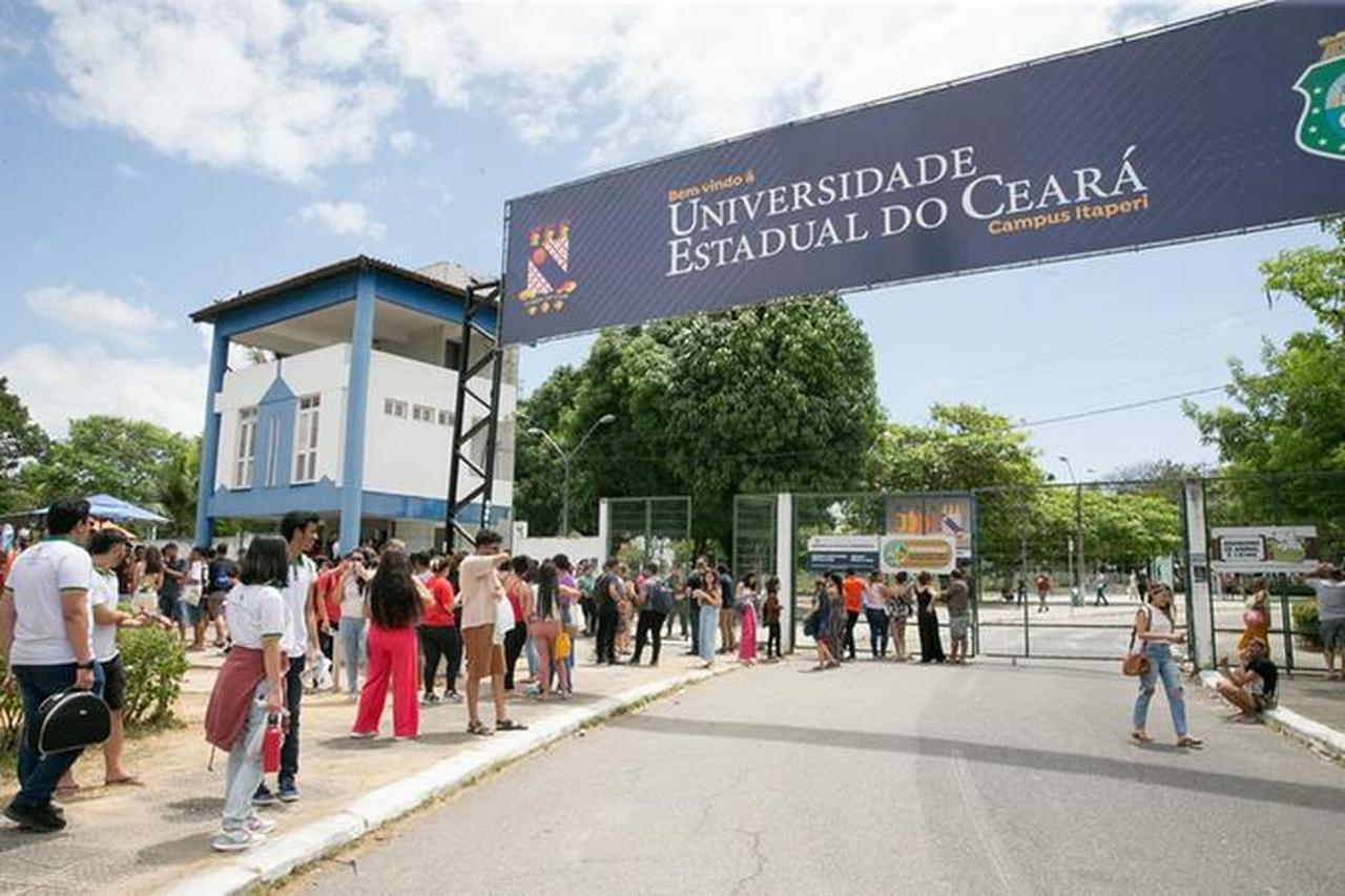 Facha de um campus da UECE com bastante movimentação de pessoas.