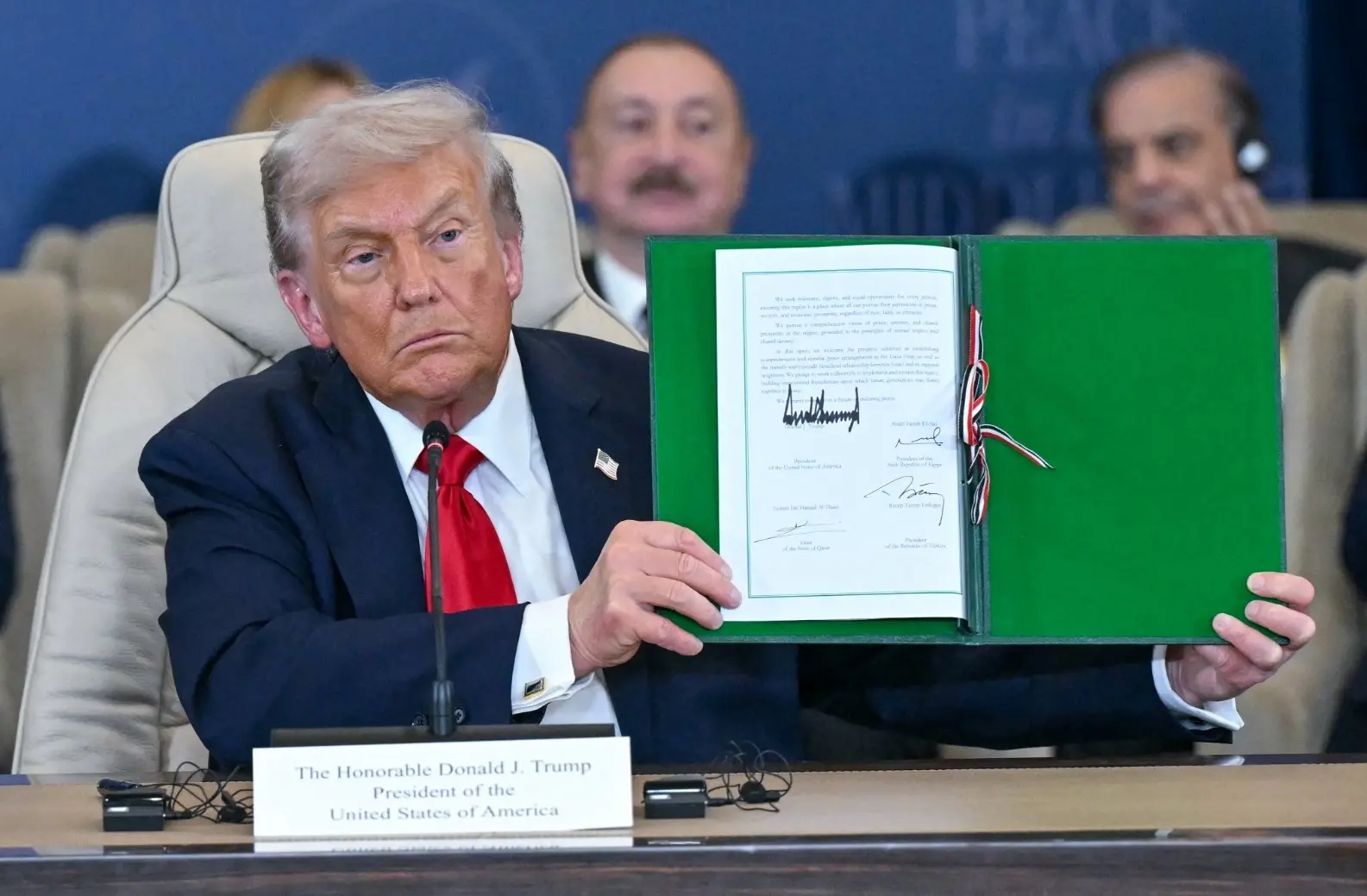 Donald Trump segura documento com assinatura de líderes mundiais para cessar fogo na Faixa de Gaza.