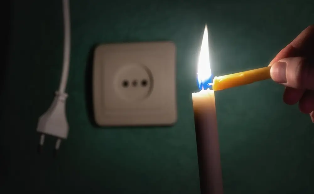 Vela acesa em frente a tomada desligada.
