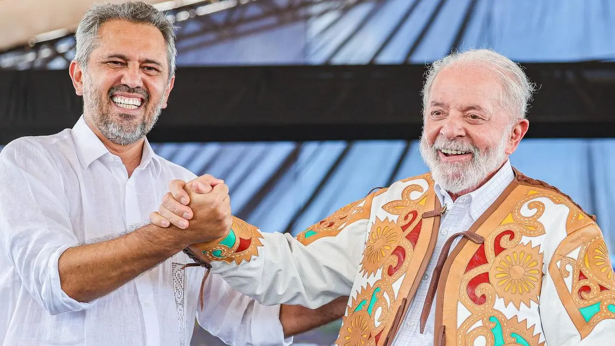 Lula e Elmano lado a lado em cima de um palco. Lula veste uma peça cearense de Espedito Seleiro