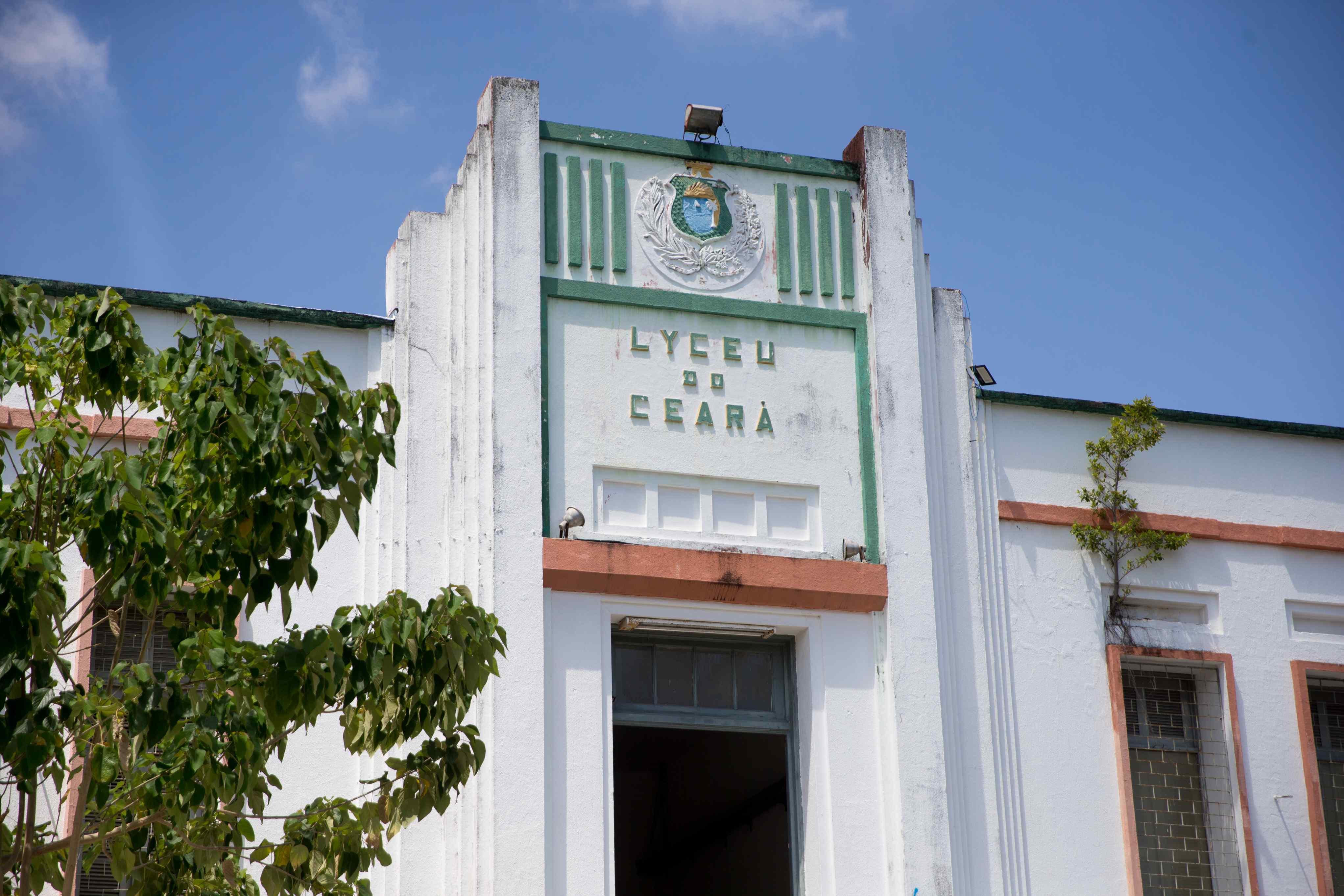 Fachada Art Déco do Lyceu do Ceará, branca com detalhes em verde e laranja. O nome 