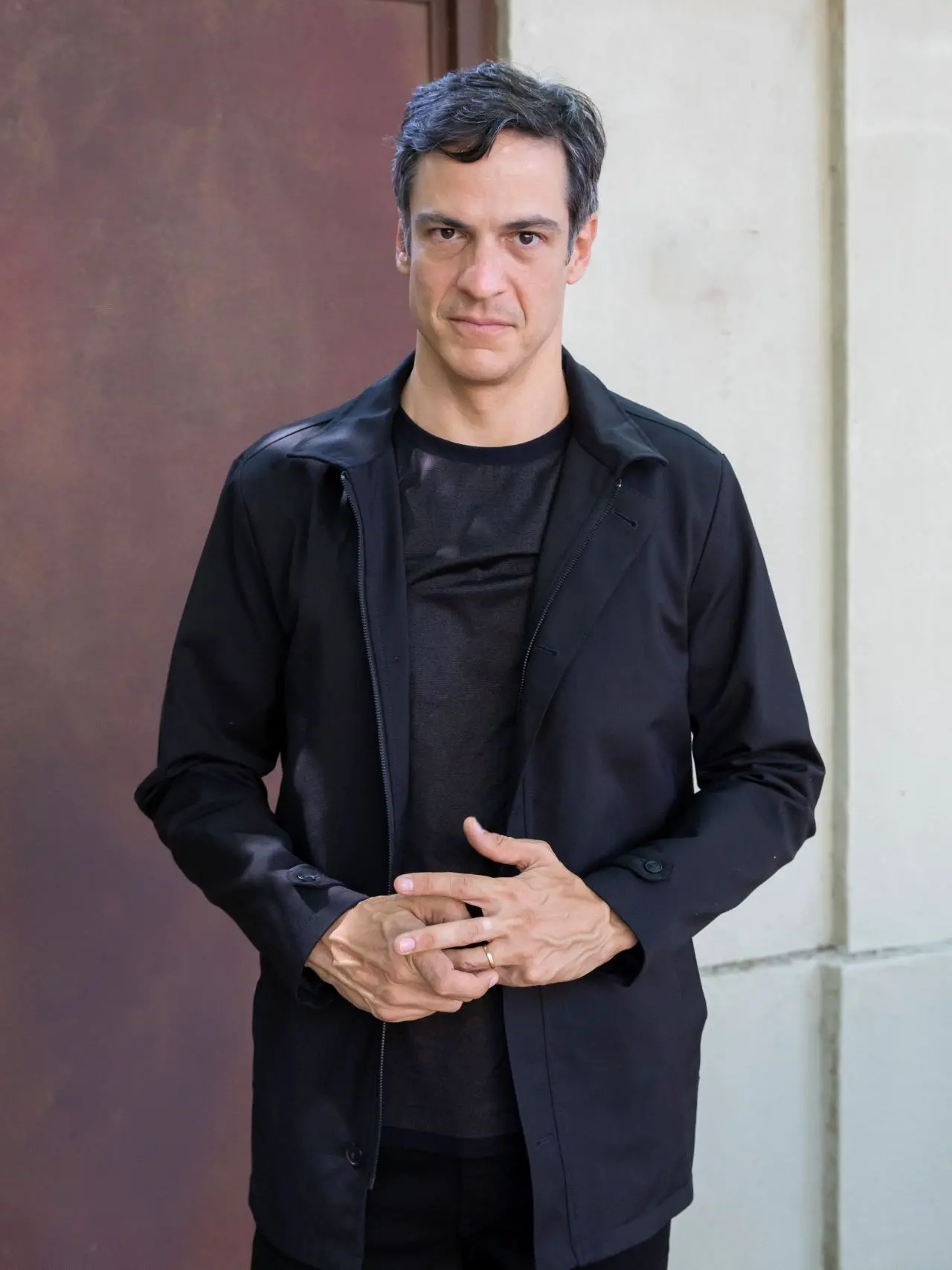 imagem de Mateus Solano. ele veste roupa preta e está diante de um fundo claro. ator bateu em celular de espectadora durante peça.