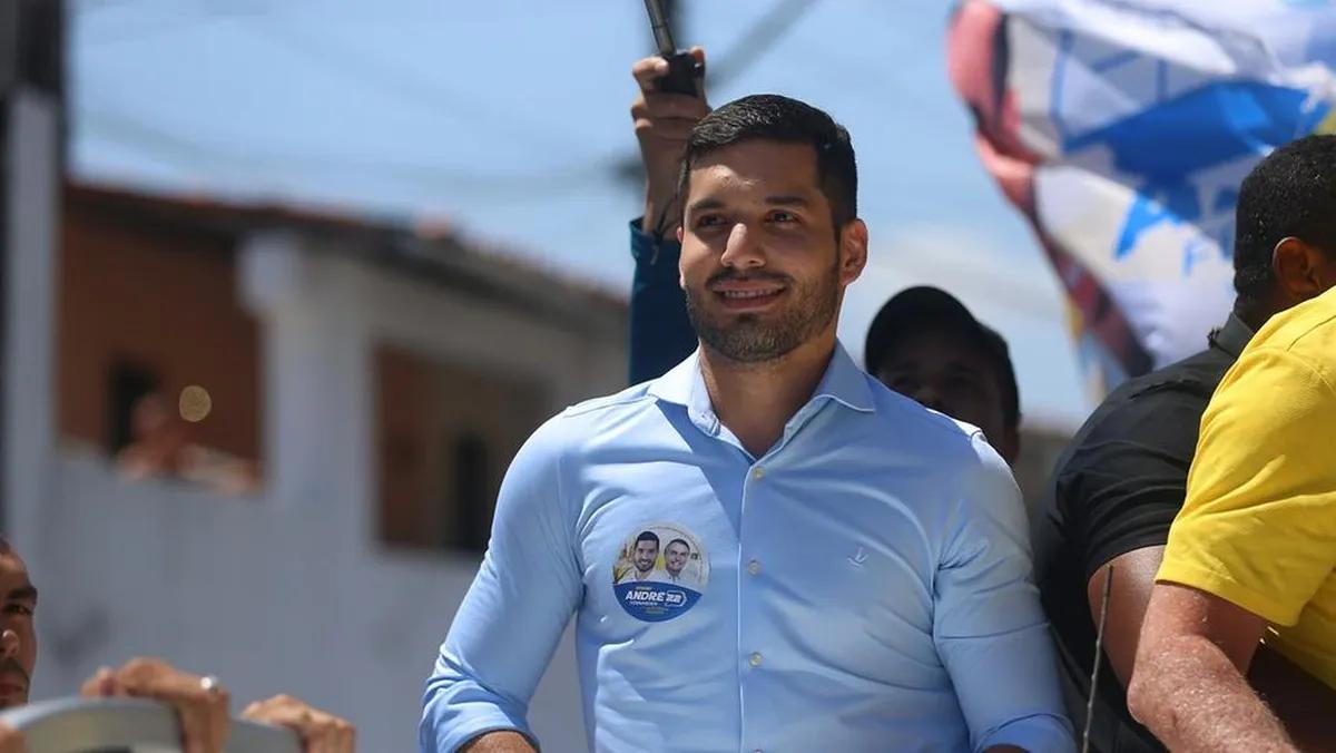 André Fernandes durante carreata na campanha eleitoral. Ele veste uma camisa azul e olha para o horizonte