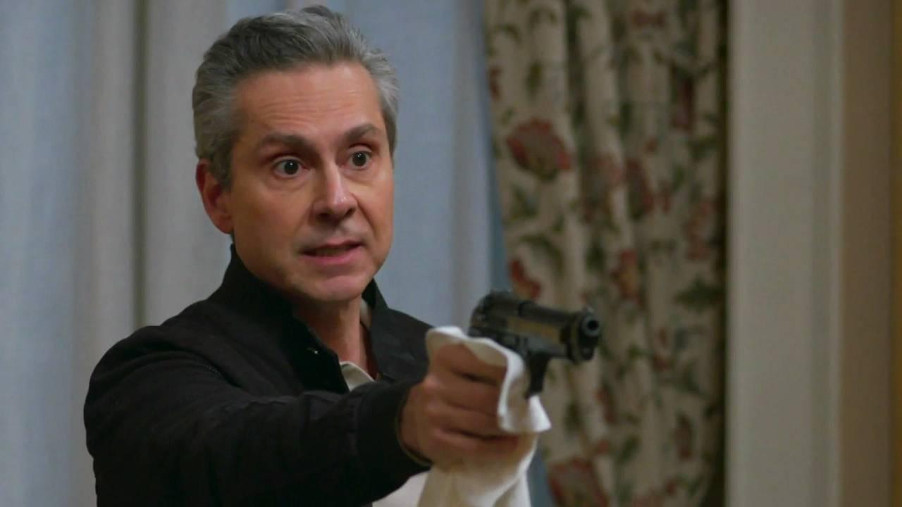 Marco Aurélio com uma arma na mão. Ele esconde digitais segurando um pano