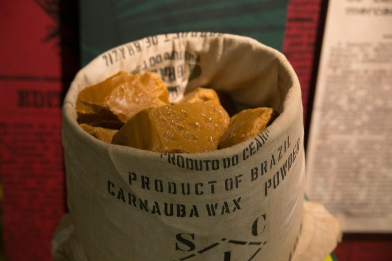 Imagem mostra recipiente com blocos sólidos na cor amarelo escuro. Esses blocos são a cera de carnaúba que é exportada.
