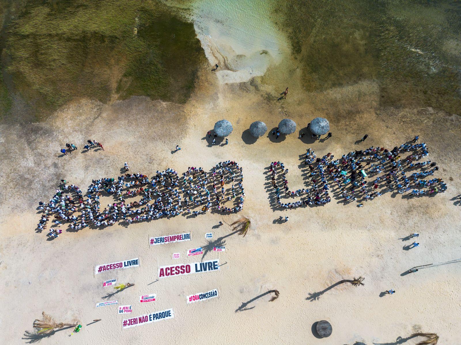 Moradores formam as palavras Acesso Livre na praia de Jericoacoara.