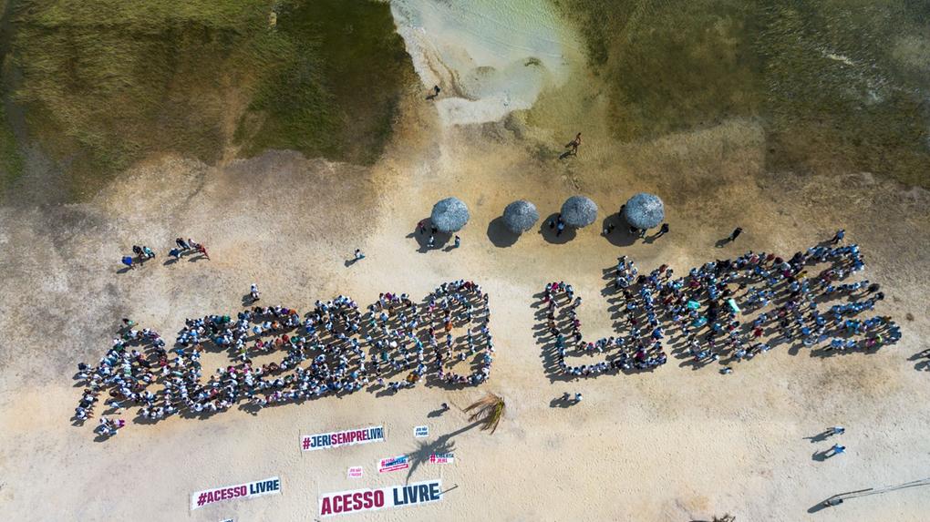 Moradores formam as palavras Acesso Livre na praia de Jericoacoara.