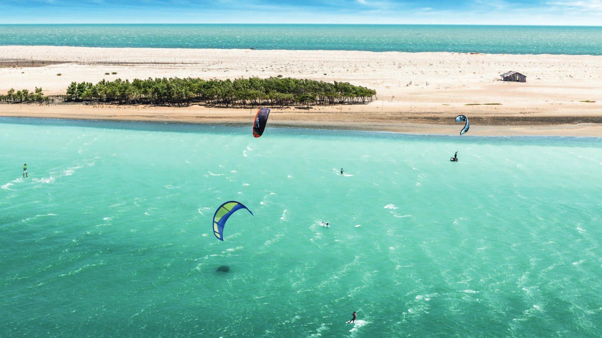 Imagem de pessoas praticando kitesurf e o windsurf durante temporada de ventos no Ceará.