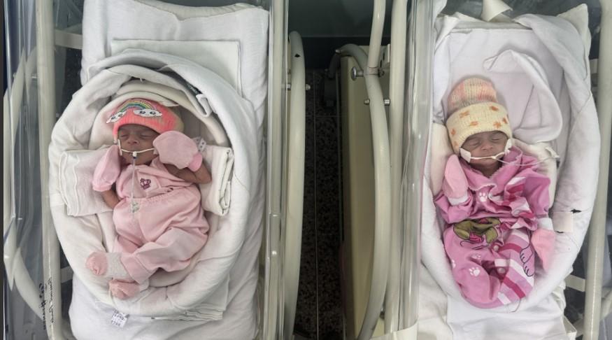 Recém-nascidos prematuros em incubadoras em hospital, com equipamentos médicos e monitoramento de saúde, destacando cuidados neonatais e assistência especializada.