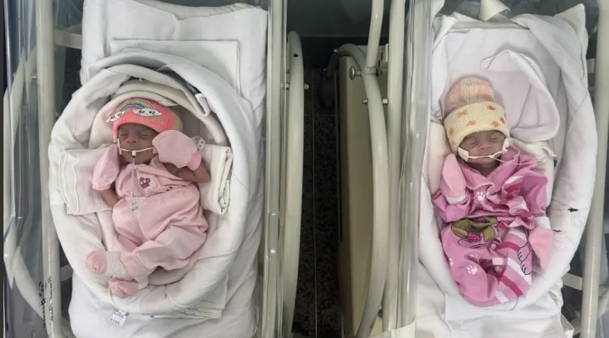 Recém-nascidos prematuros em incubadoras em hospital, com equipamentos médicos e monitoramento de saúde, destacando cuidados neonatais e assistência especializada.