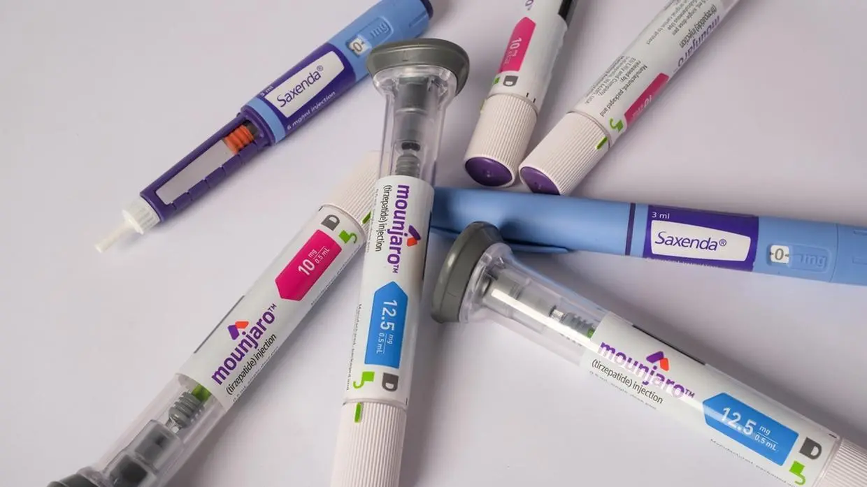 A imagem mostra várias canetas injetoras de medicamentos, dispostas sobre uma superfície branca.