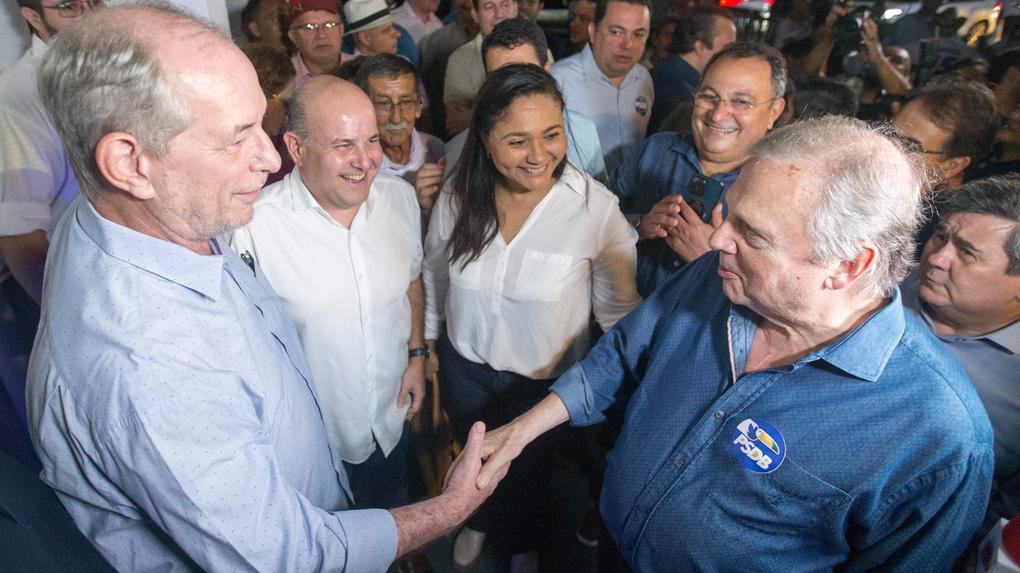 Ciro e Tasso trocam cumprimentos durante evento do PSDB. Ao fundo, um grupo de pessoas, entre eles Roberto Cláudio