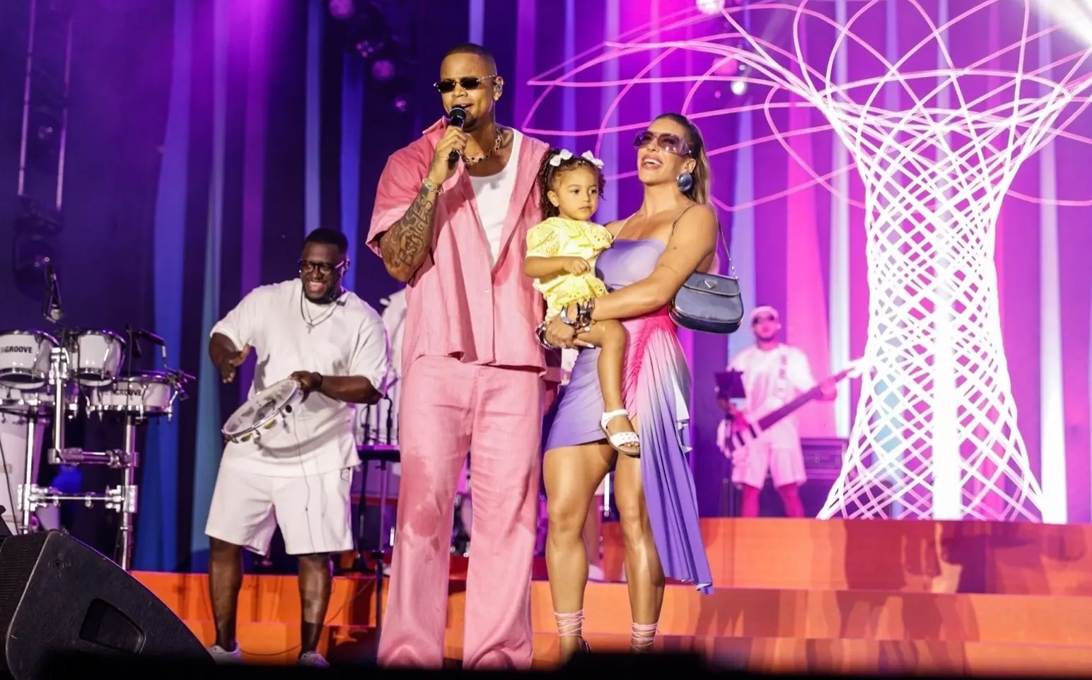 Léo Santana, Lore Improta e Liz em palco de show.