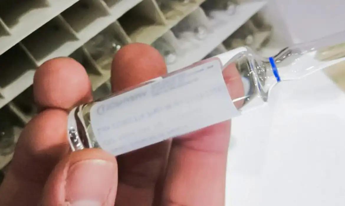 Mão segura frasco de etanol farmacêutico.