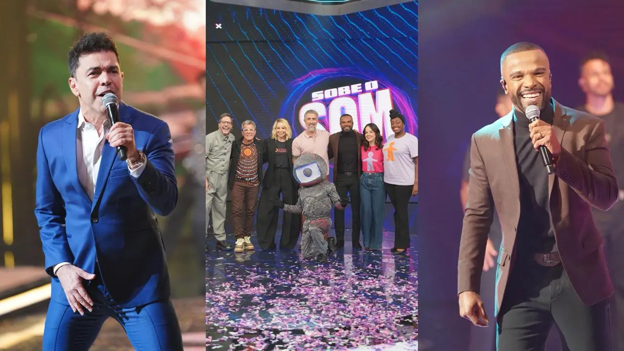 A imagem mostra três homens e uma mulher em um evento musical, com um palco iluminado ao fundo, celebrando com roupas formais e casuais, e um público animado.