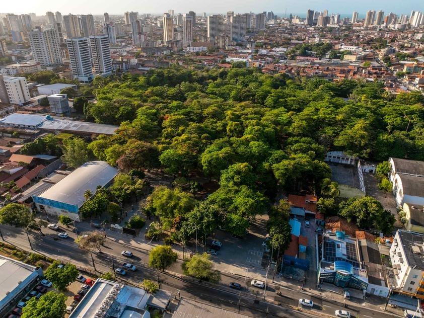 Imagem aérea de Fortaleza destaca área verde em meio a prédios altos.