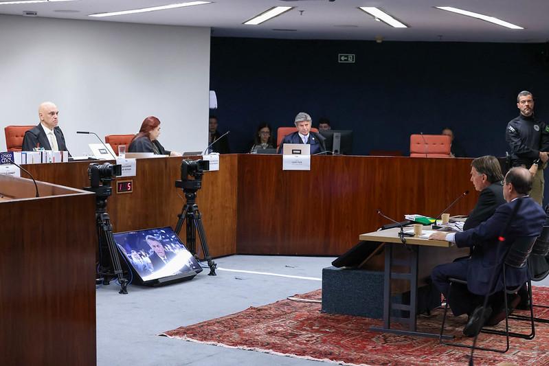 Foto mostra Jair Bolsonaro e Alexandre de Moraes, frente a frente, durante um interrogatório no STF.