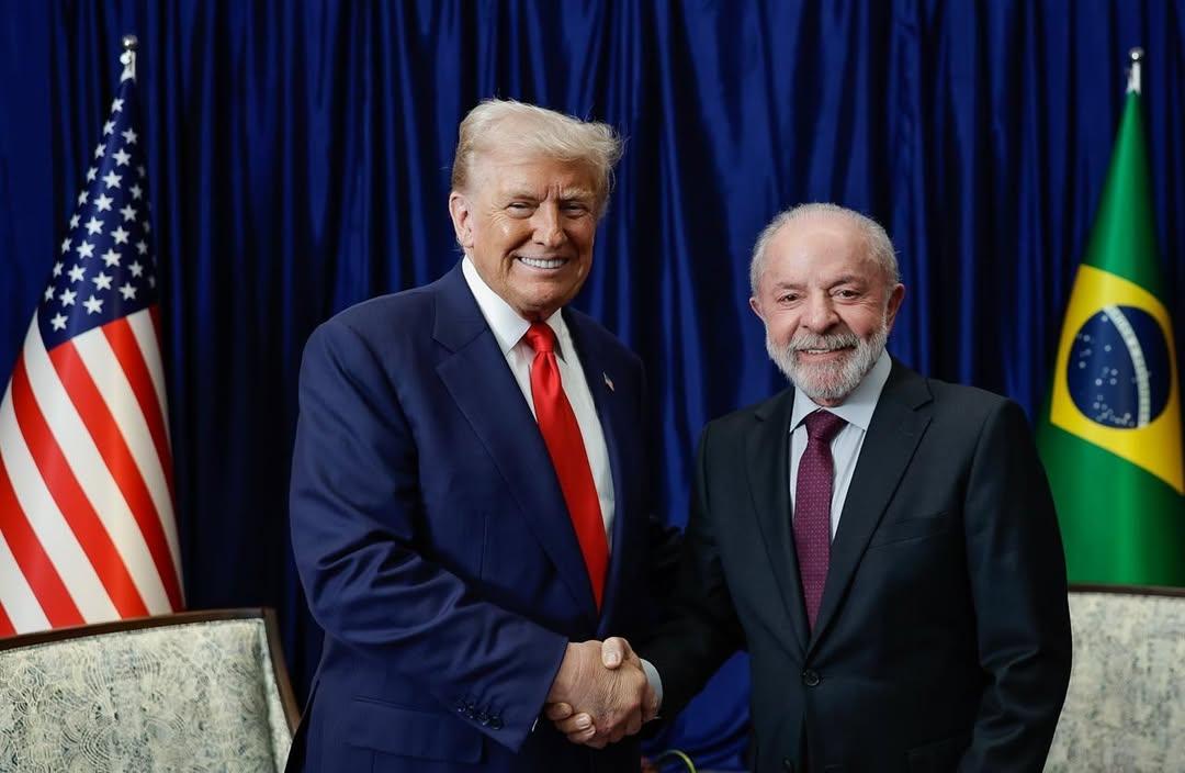 Trump e Lula em encontro na Malásia. Em foto, eles apertam as mãos e dão sorrisos.