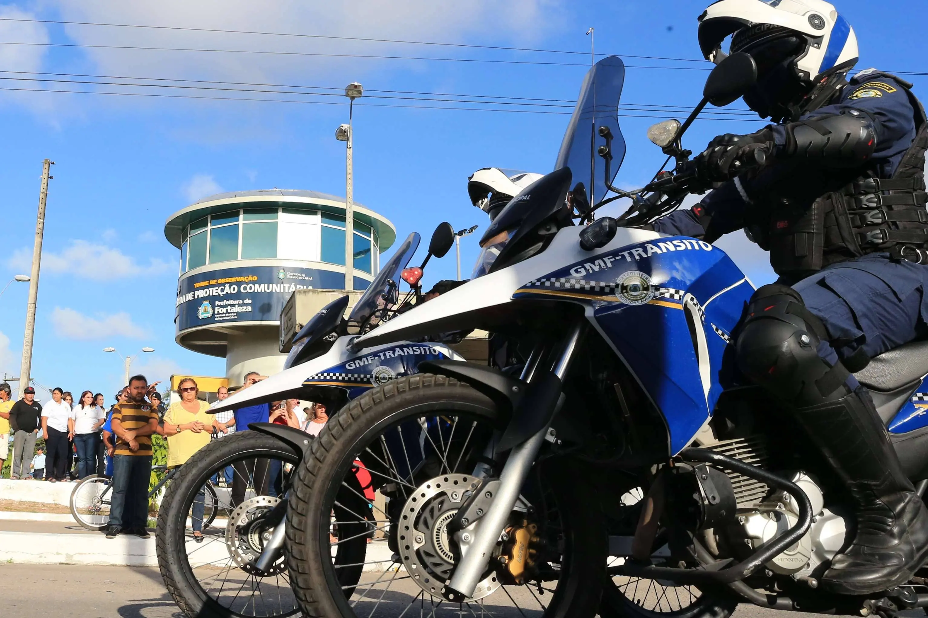 A foto mostra agentes da Guarda Municipal de Fortaleza em motos, próximos de uma torre de monitoramento no bairro do Jangurussu.