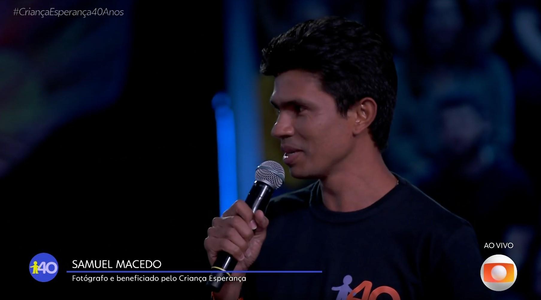 imagem mostra o fotógrafo samuel macedo falando ao microfone durante homenagem a renato aragão no criança esperança