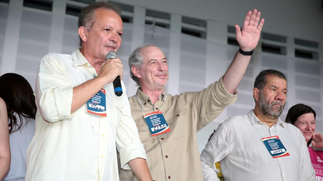 André Figueiredo, Ciro Gomes e Lupi. André discursa segurando um microfone, Ciro acena com a mão e Lupi olha para o horizonte.