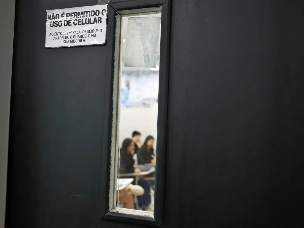 Foto de candidatos do enem em sala de aula fazendo a prova.
