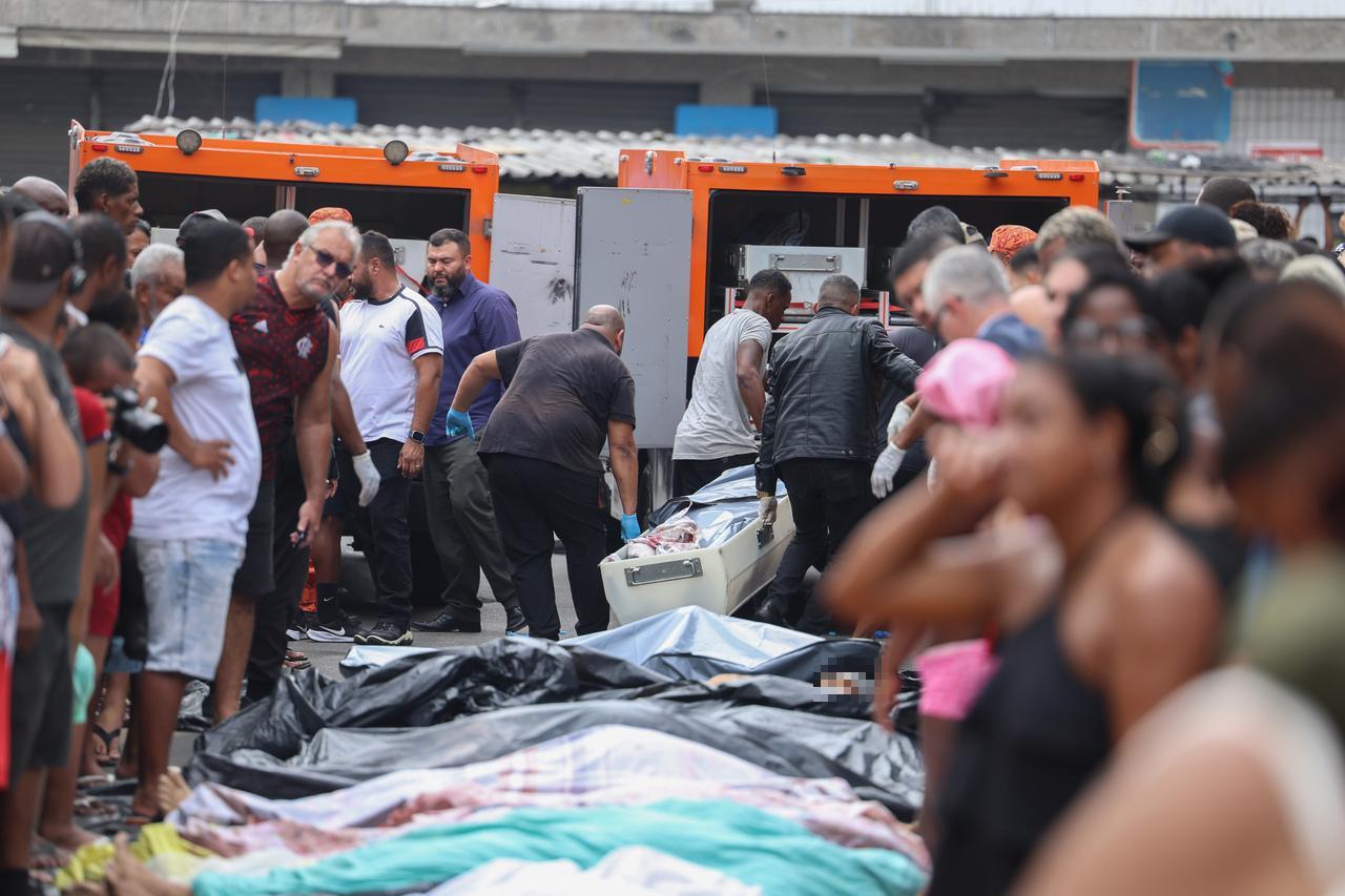 A foto mostra vários corpos enfileirados, em uma rua, na Penha, no Rio de Janeiro, e pessoas consternadas em volta, após uma megaoperação policial.
