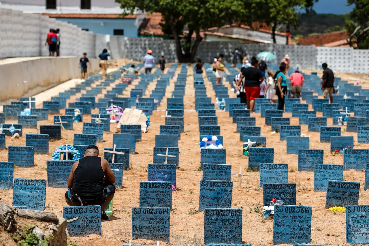 Visita ao cemitério com várias sepulturas marcadas, usuários refletindo e homenageando entes queridos em um ambiente tranquilo ao ar livre.