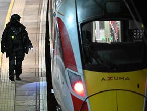 Um agente da polícia caminha na plataforma ao lado de um trem LNER Azuma na estação de Huntingdon, em Huntingdon, no leste da Inglaterra, em 1º de novembro.