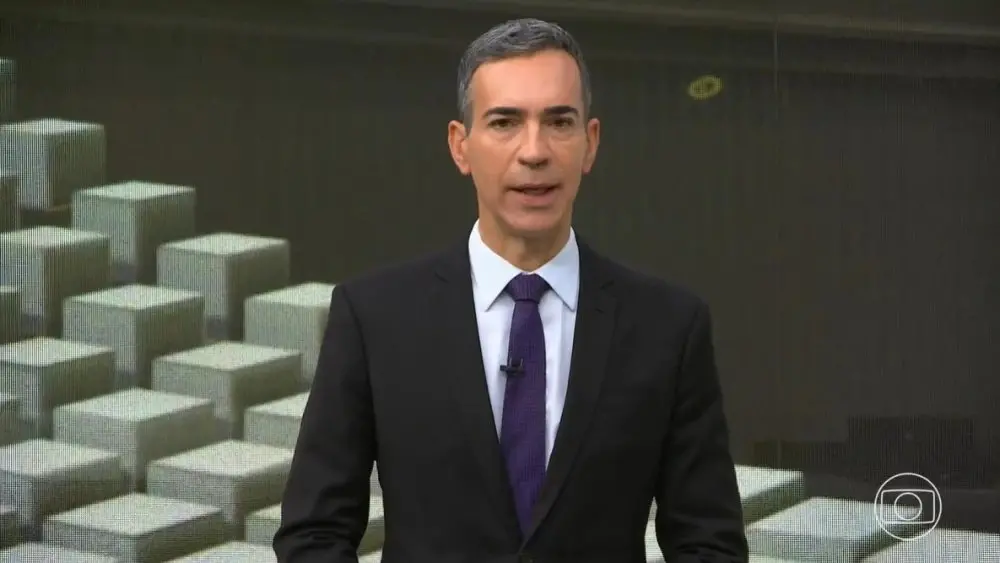 César Tralli de terno preto e gravata azul-escuro, apresentando o Jornal Hoje.