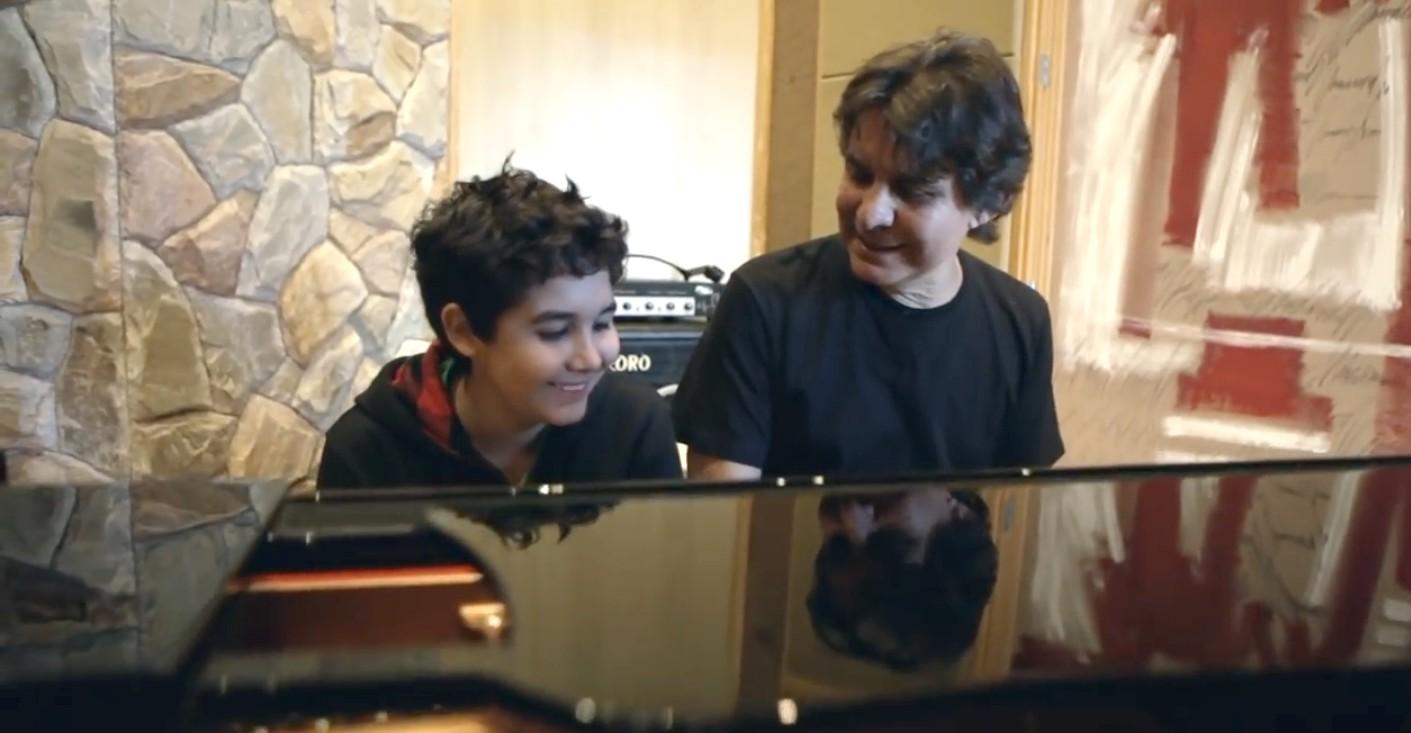 Lô Borges ao lado do filho Luca ao piano, aos 12 anos.