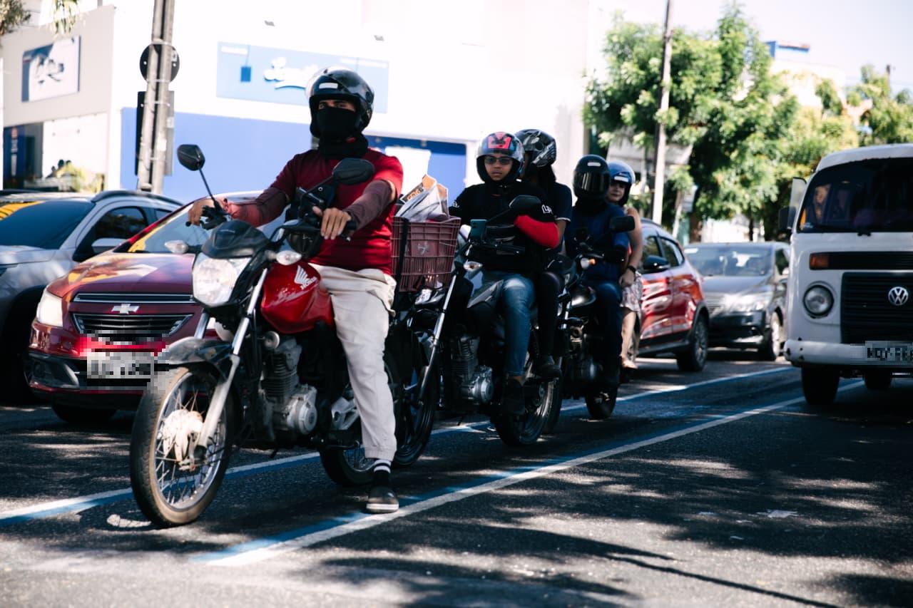 Motociclistas enfileirados na faixa azul parados em semáforo na avenida Humberto Monte.