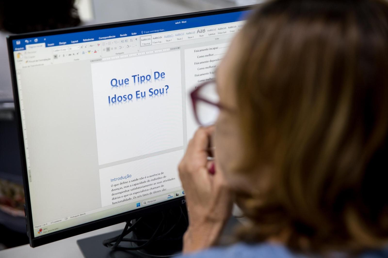 Idosa lê tela de computador com a mão no queixo. Na tela, está escrito: Que tipo de idoso eu sou?