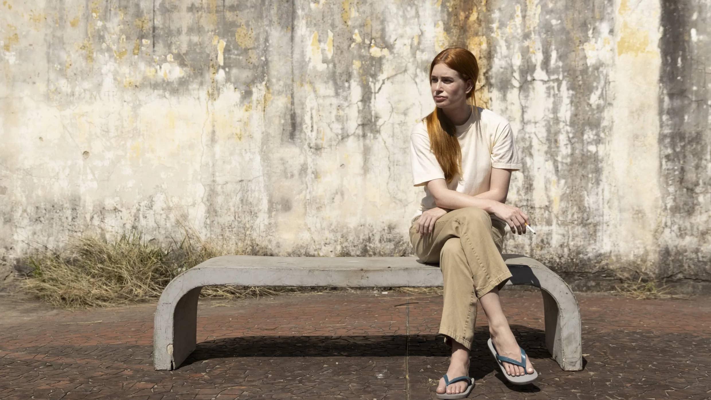 Marina Ruy Barbosa sentada no cenário do presídio fumando