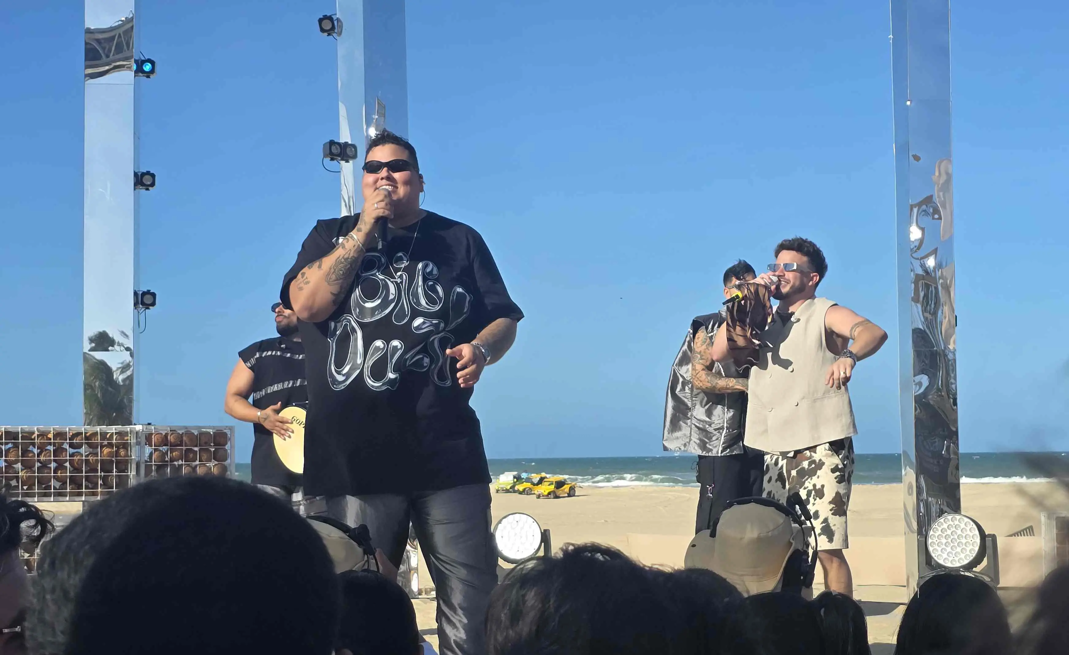 Cantor Duzão no palco do DVD 'Fala Meu Nome' com Matheus Fernandes. Na foto, o público aparece na frente do palco. Ao fundo, o céu azul.