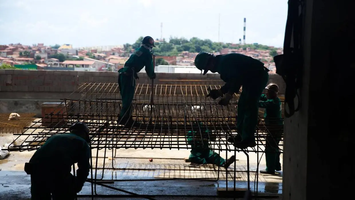 Imagem mostra trabalhadores em obra.