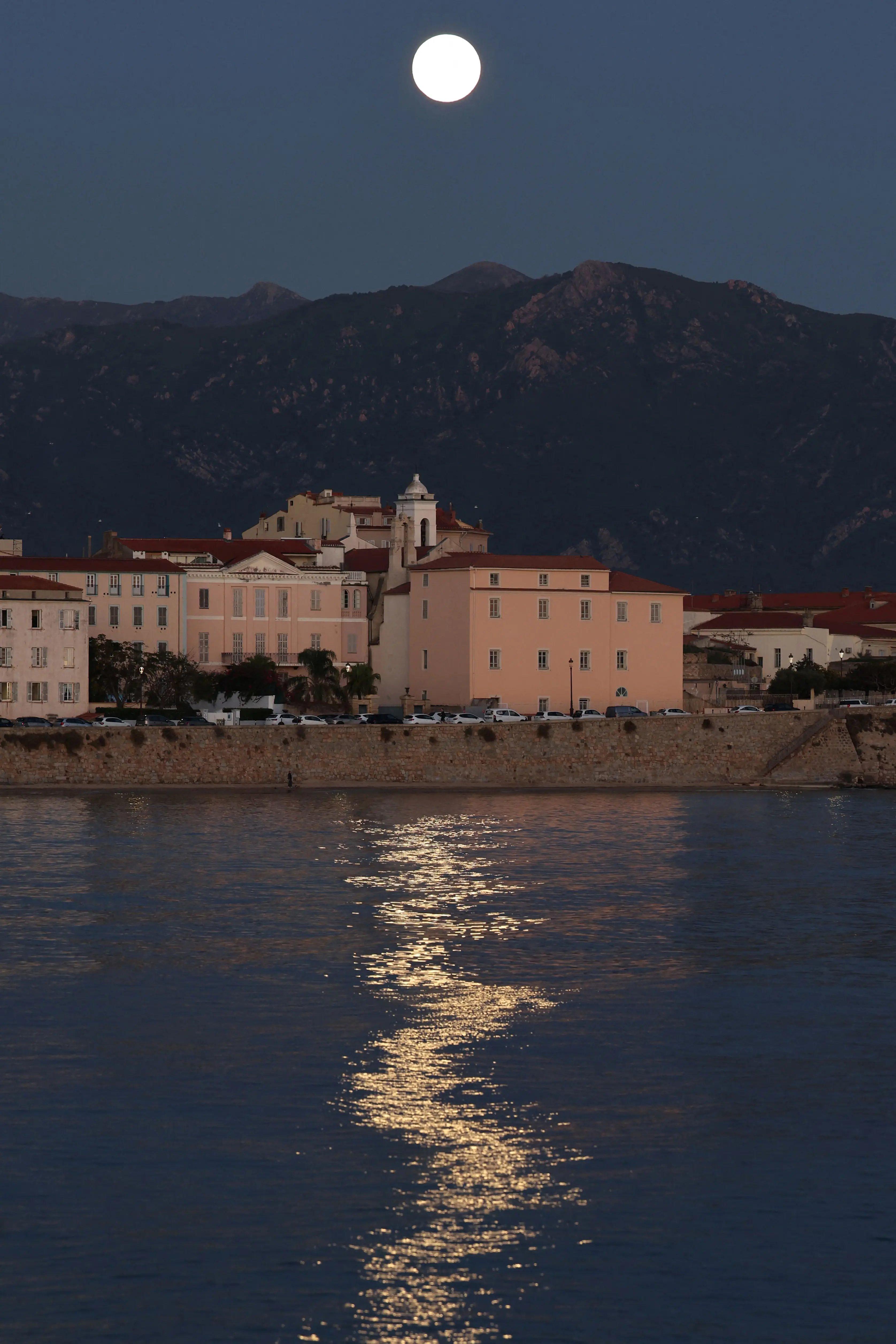 Imagem mostra a última superlua de 2025 refletida no mar sobre a cidade velha de Ajaccio, na ilha francesa da Córsega, no Mediterrâneo.