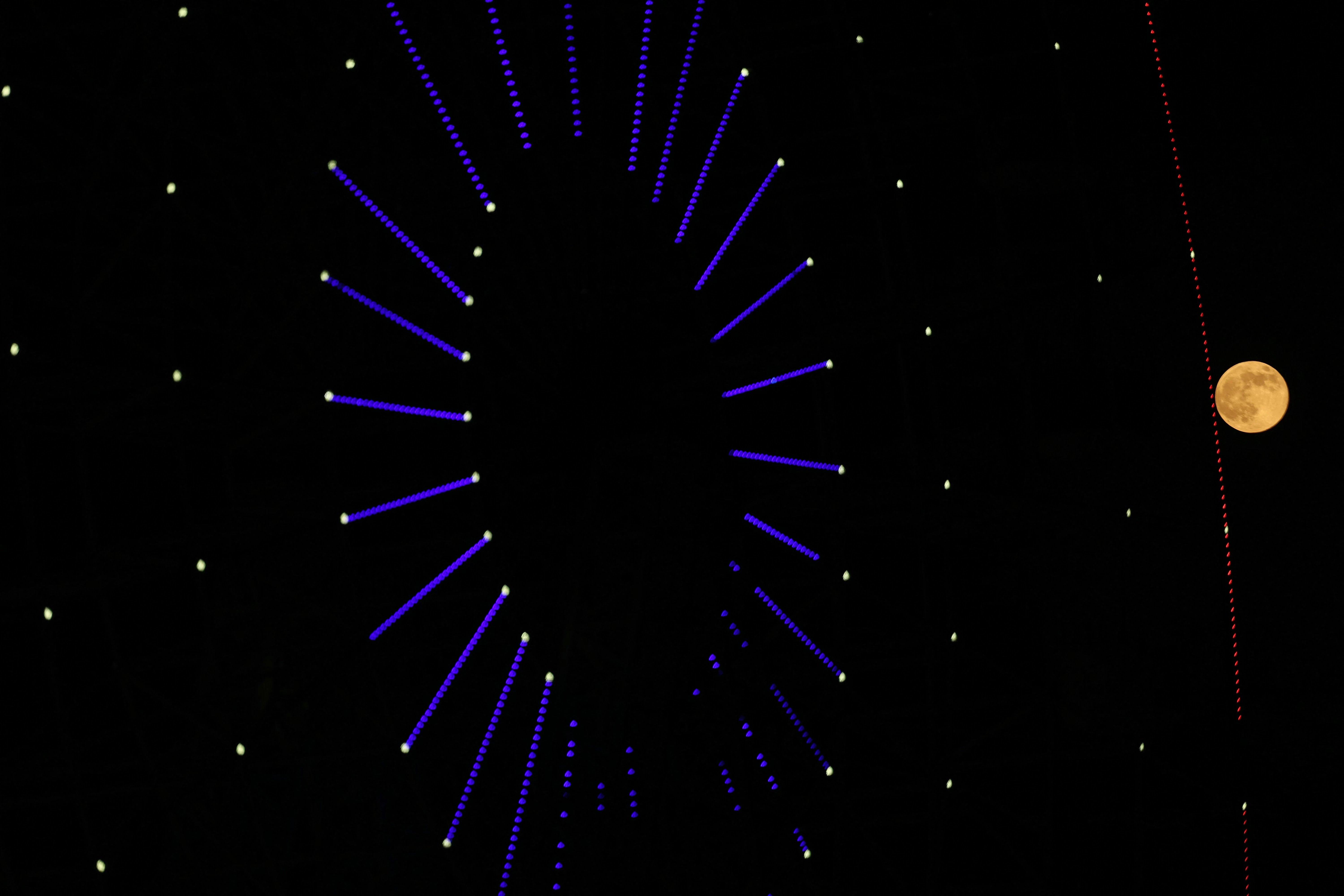 Imagem da superlua é retratada ao lado de uma roda giratória na cidade de Idlib, no norte da Síria, em 5 de novembro de 2025.