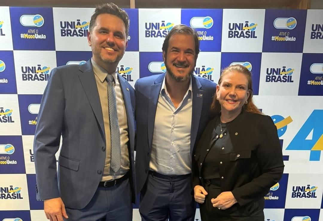 Fernanda Pessoa, Moses Rodrigues e Antônio Rueda posam para uma foto em frente a um banner do União Brasil, em Brasília.