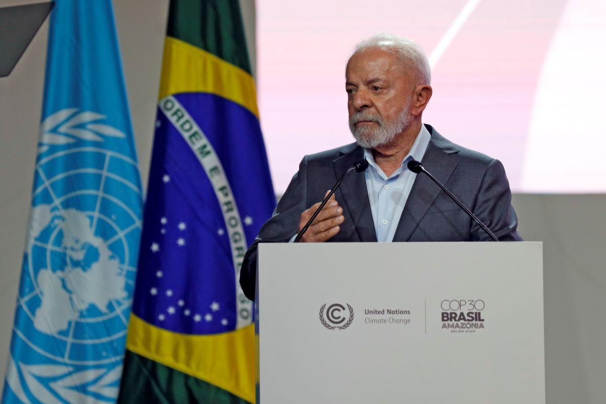 Na foto, o presidente Lula discursa no evento de abertura da COP30. Ele está em um púlpito branco com o nome COP 30 BRASIL e o símbolo da ONU.