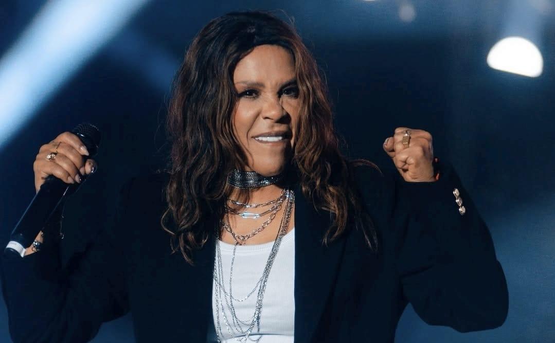 Foto de Silvânia Aquino cantando durante um show.