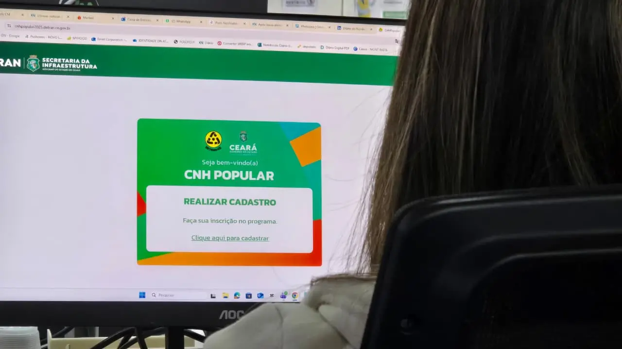 Uma pessoa na frente da tela do computador no sistema do Detran-CE fazendo inscrição da CNH Popular