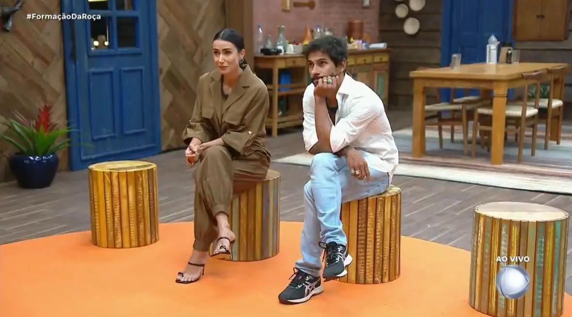 Imagem mostra o casal Shia e Michelle recebendo a informação de que foram eliminados.