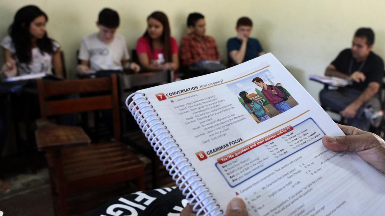 foto de aluno com livro de inglês nas mãos em sala de aula.