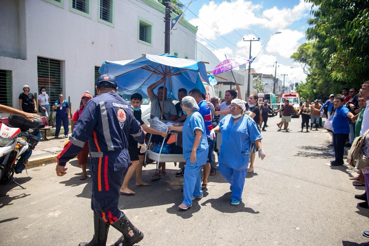 Funcionários do hospital e socorristas transportam bebês em incubadoras para o Beco da Poeira.