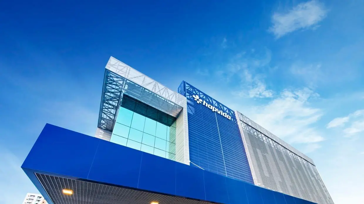 Fachada moderna de unidade da Hapvida sob céu azul.