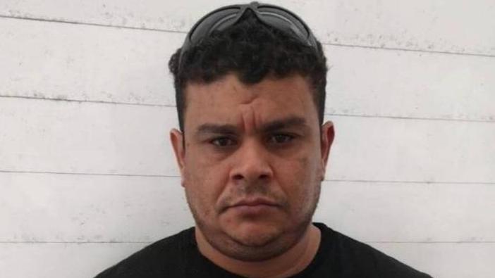 Imagem mostra Valério Rodrigues de Araújo, conhecido como Lerim, de camiseta preta e óculos escuros na cabeça olhando para a câmera.